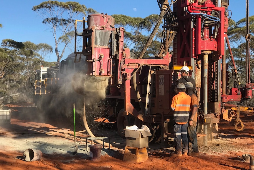 Workers operate a drilling rig at a Nimy Resources prospecting site. 