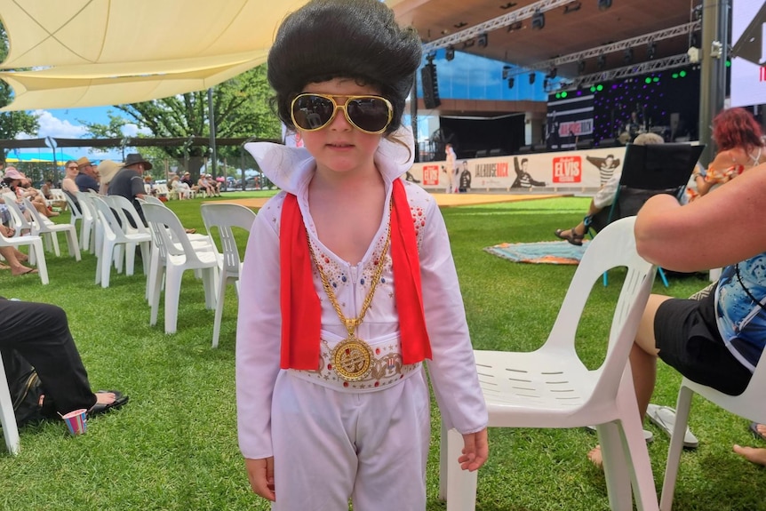 A young boy dressed up as Elvis.
