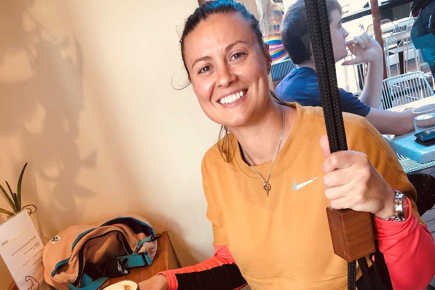 A woman sits in a cafe with a coffee on a swing