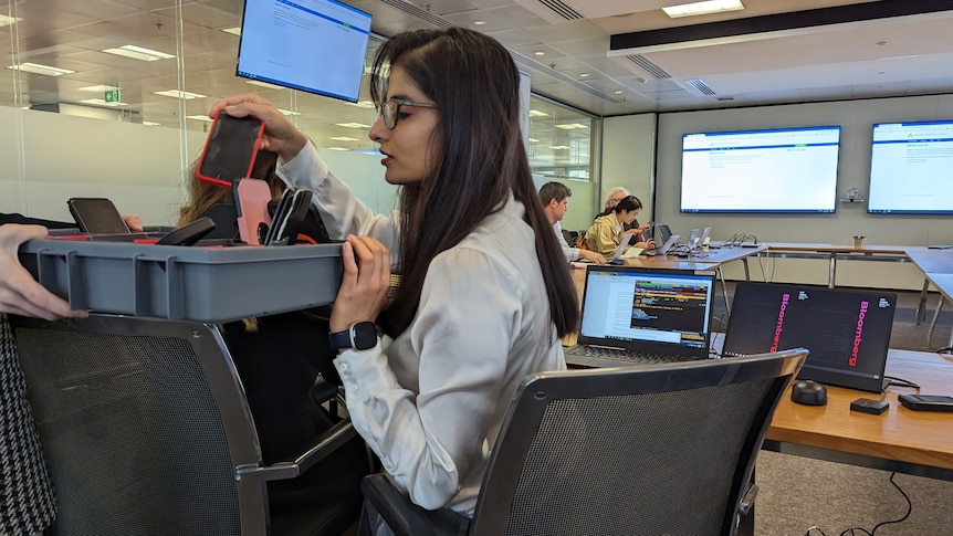 The Reserve Bank staff collect journalists' phones.