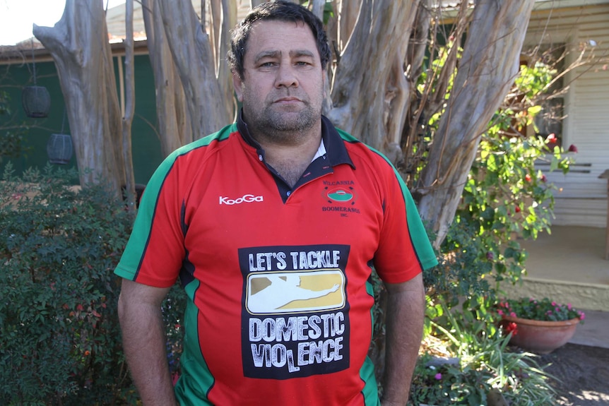 Wilcannia community leader Brendon Adams wearing a 'Let's Tackle Domestic Violence' jersey.
