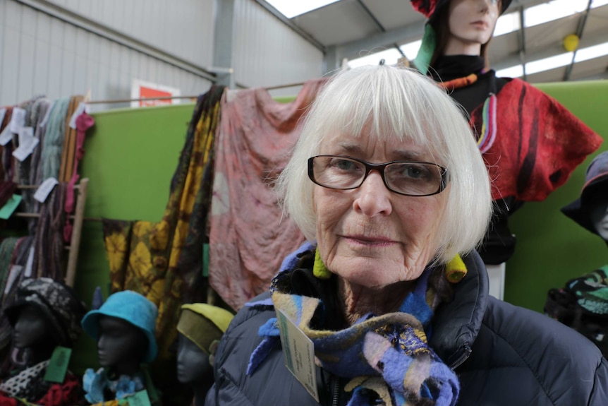 Penny Fontaine stands in front of a display of her felt hats