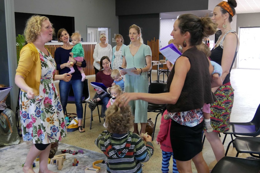 Mothers with their children sing in a choir.