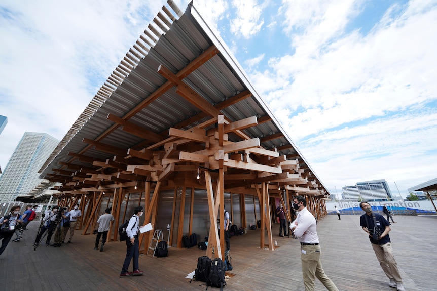 Journalist walk at the Village Plaza made up of timber beams near Tokyo 2020 Olympic and Paralympic Village