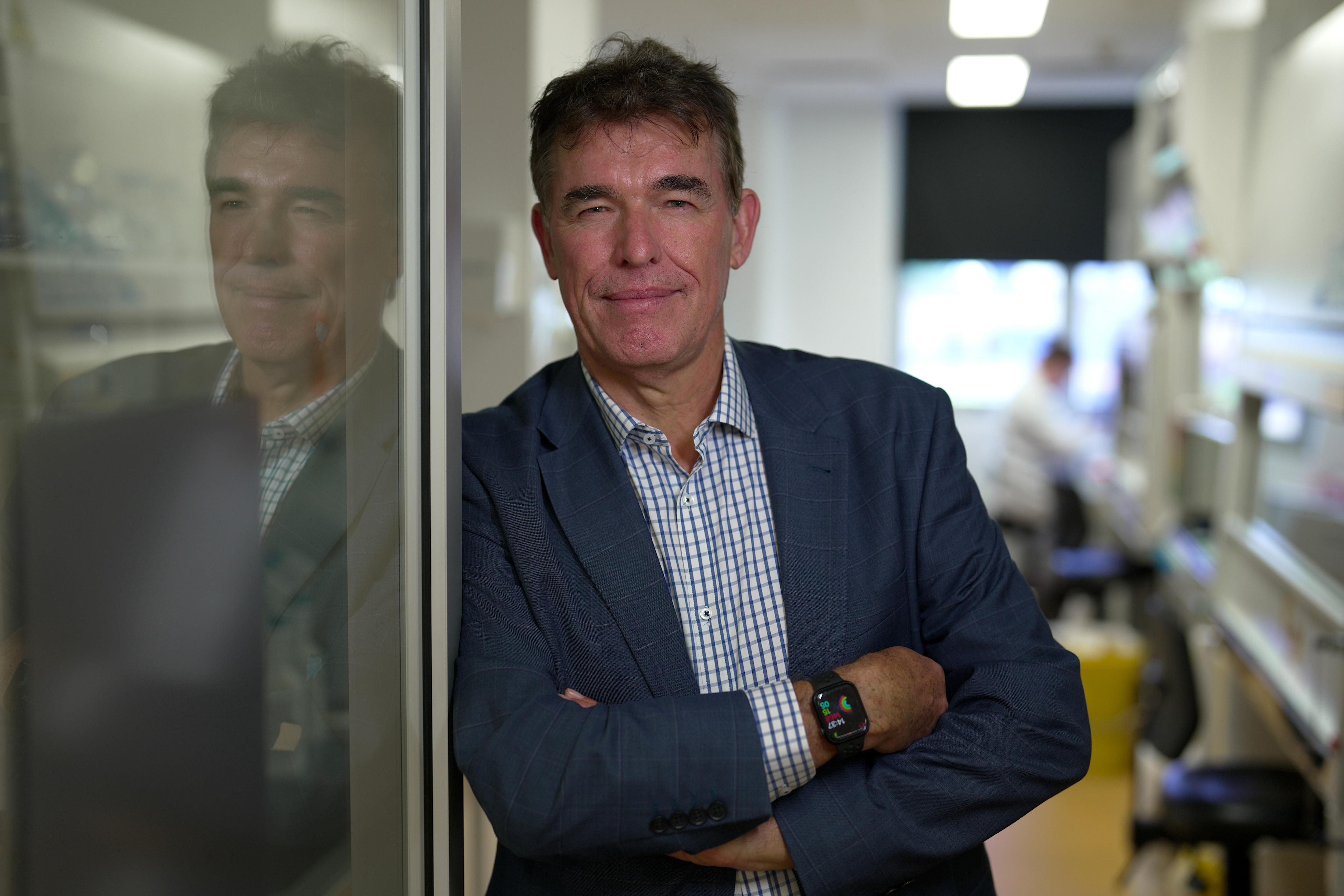 A man leans against a glass door.