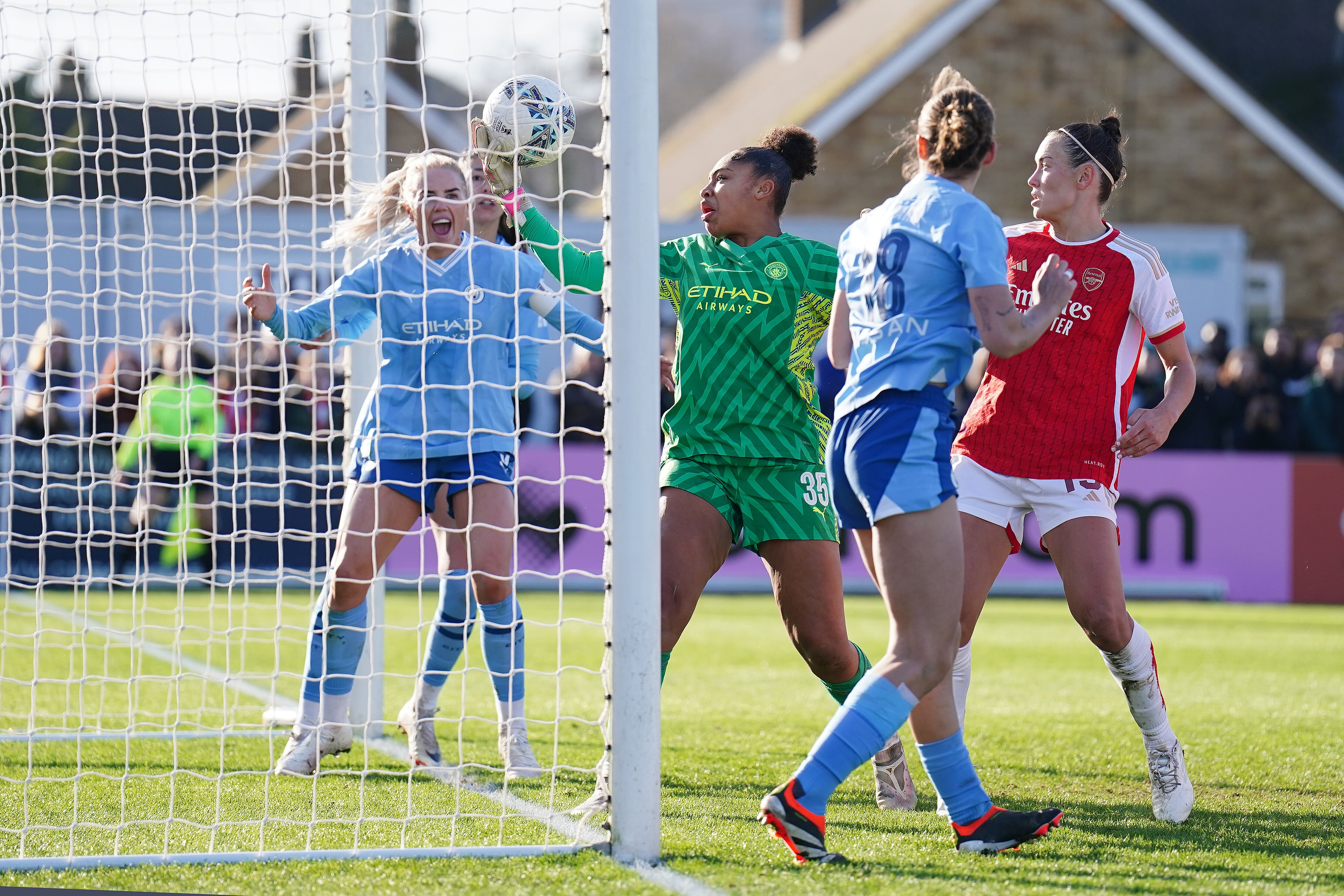 Caitlin Foord and Arsenal players appeal to the referee as Manchester City goalkeeper Khiara Keating catches a ball on the line.