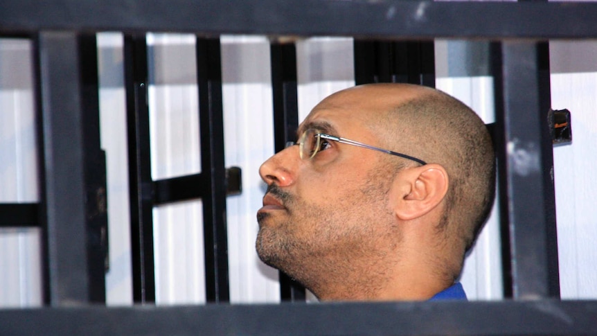Saif al-Islam Gaddafi, son of late Libyan leader Muammar Gaddafi, attends a hearing behind bars in a courtroom in Zintan May 25, 2014