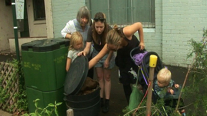 A family inspect public compost bins in Chippendale community garden.