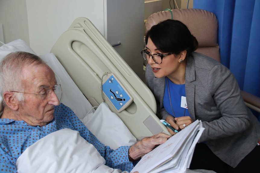 Patient Alan Trethewey in a hospital bed with artist and illustrator Alyssa Bermudez in Hobart, May 2019.