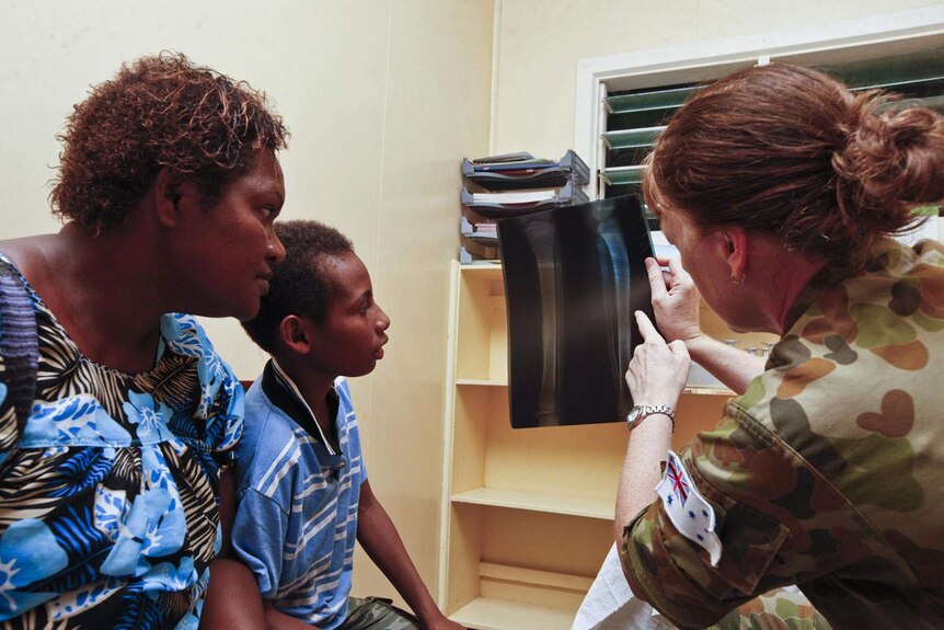 Nurse explains x-ray results during Pacific Partnership 2013 health clinic in PNG