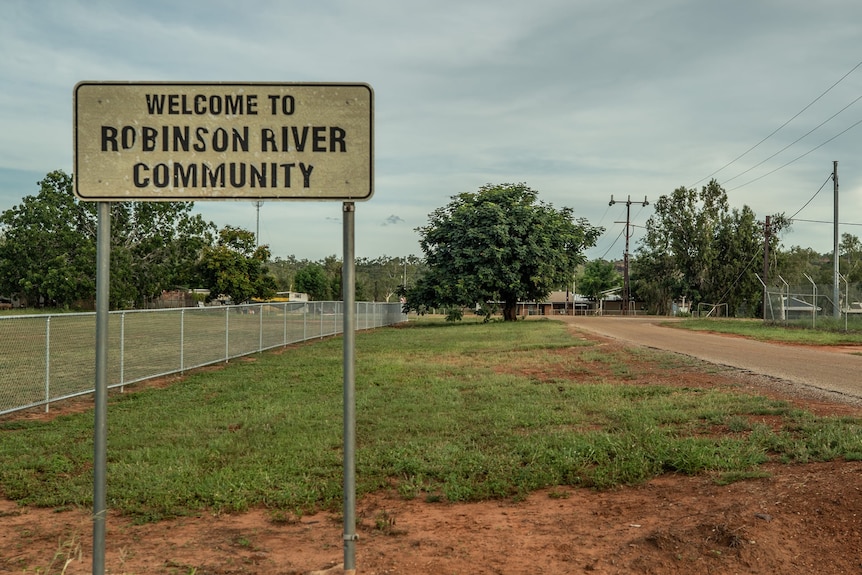 A sign saying 'welcome to Robinson River community' by an oval.