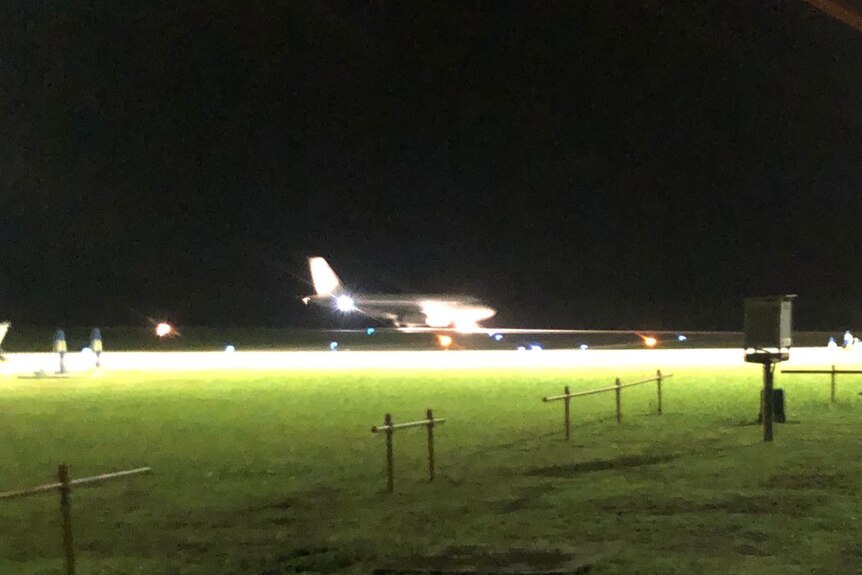 A long shot showing a plane which has just landed on the runway on Christmas Island at night.