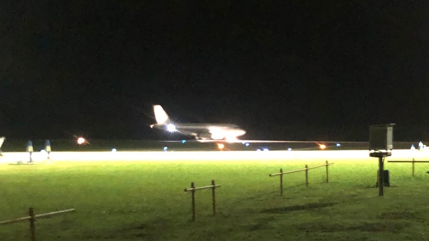 A long shot showing a plane which has just landed on the runway on Christmas Island at night.
