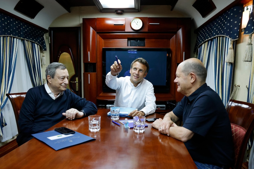 French, German and Italian leaders talks to each other on a train