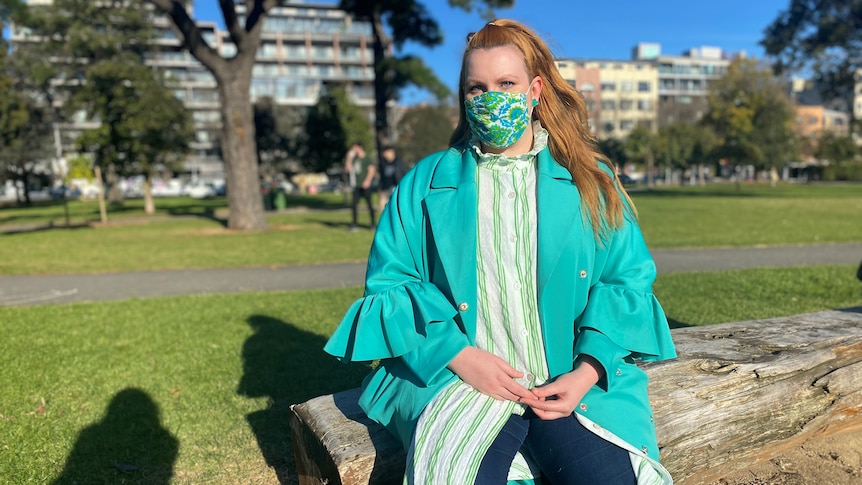  young woman with a covid mask on a park bench
