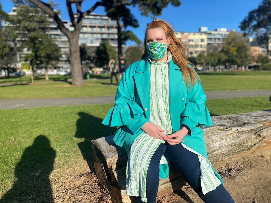  young woman with a covid mask on a park bench