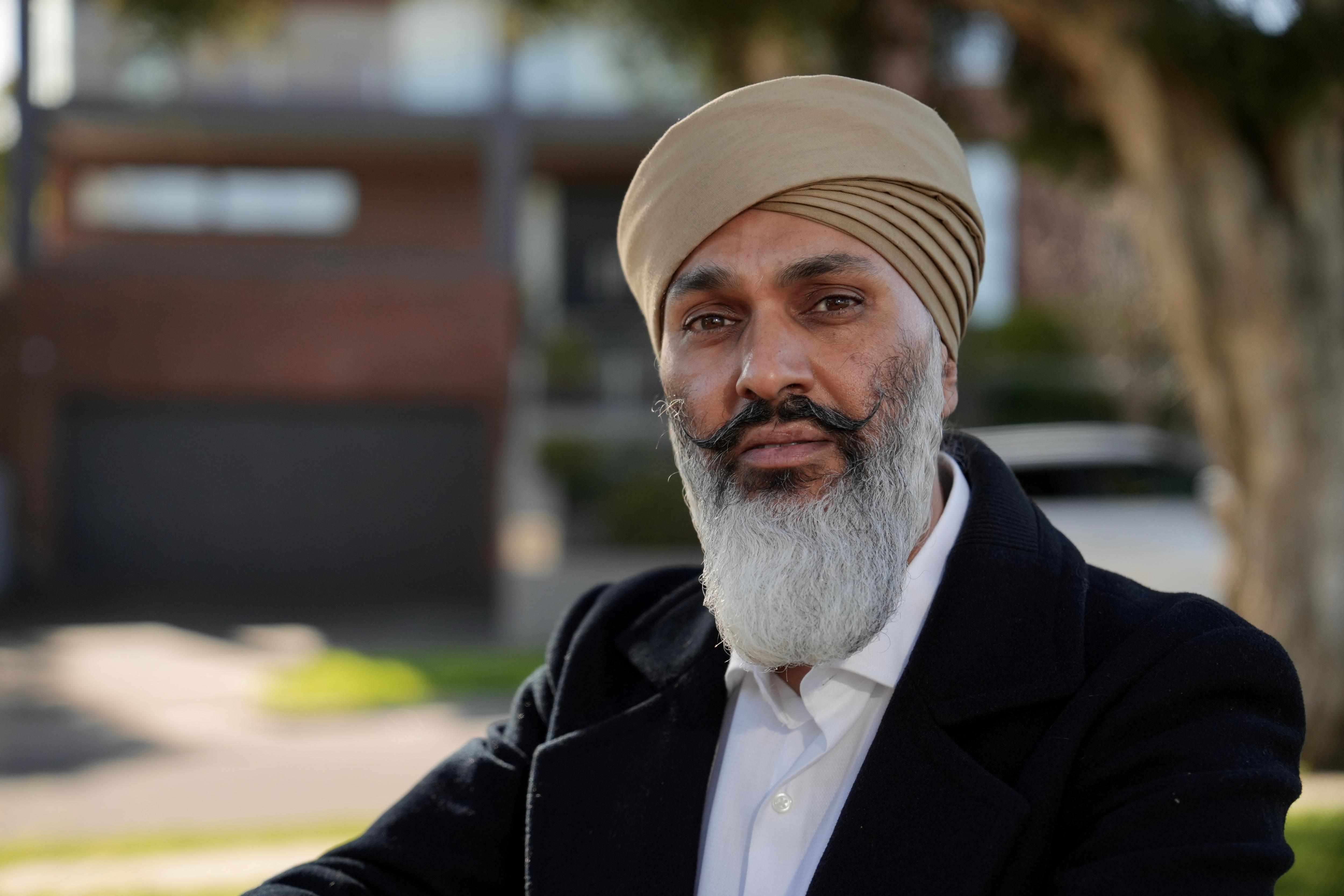 A Sikh man looks at the camera seriously.