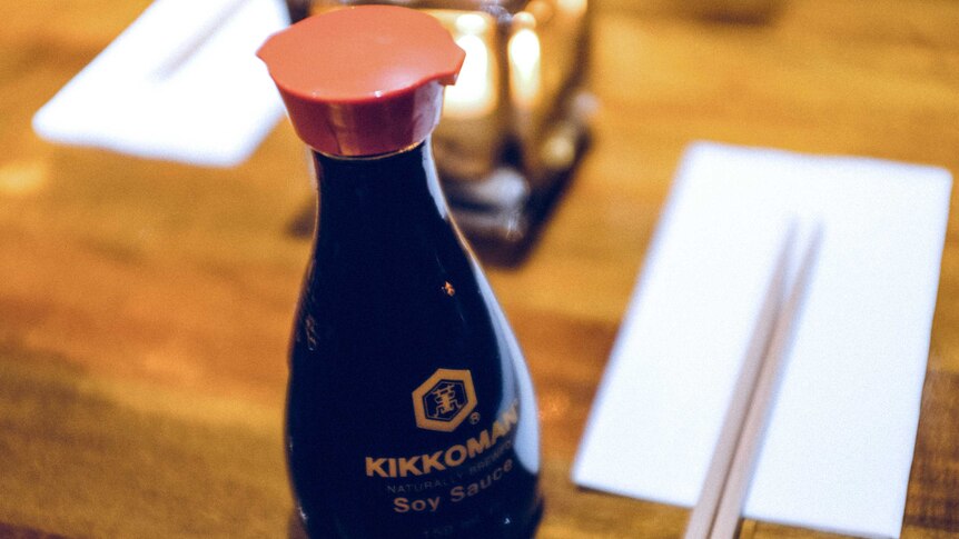 Bottle of soy sauce and chopsticks.