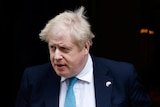 A close up of Boris Johnson exiting Downing Street with a neutral expression on his face.