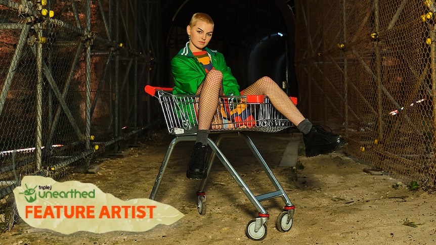 Molly Millington, with short blonde hair and a green jacket, sits in a trolley.