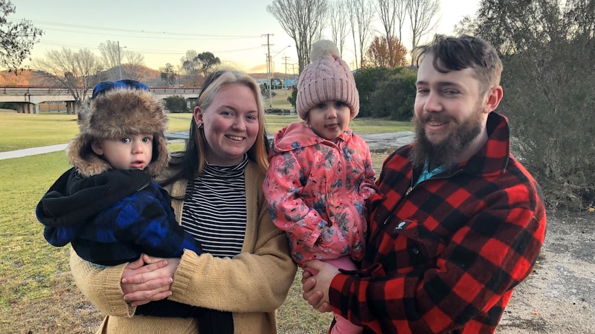 A mum, dad and two young kids dressed up in warm clothes.