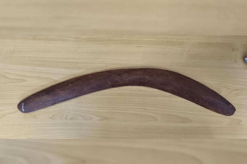 a long brown wood boomerang 