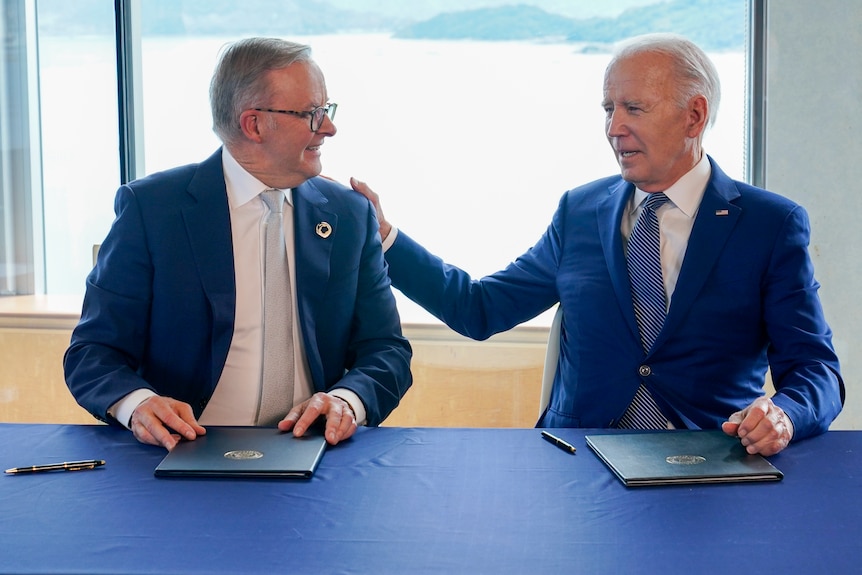 Joe Biden puts a hand on Anthony Albanese's shoulder