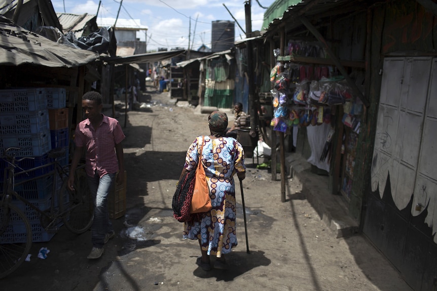 A woman walks on a street at the Mukuru Kwa Njenga slum in the capital Nairobi, Kenya