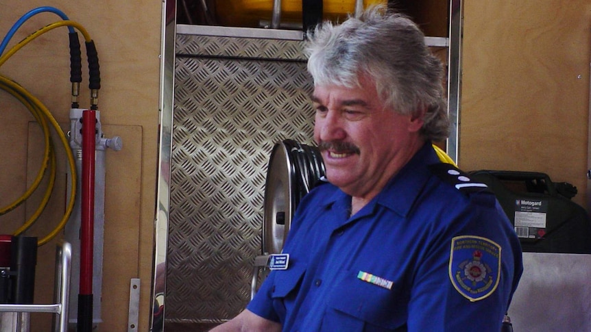 An ageing man in a firefighter's uniform.