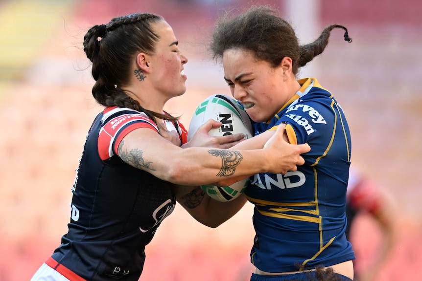 A Parramatta Eels NRLW player is tackled by a Sydney Roosters opponent.