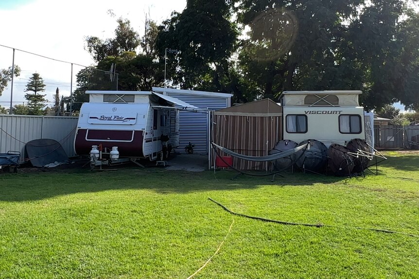a photo of two caravans in backyard