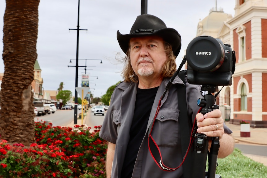 A man with his canon camera standing in the middle of Boulder's main street 