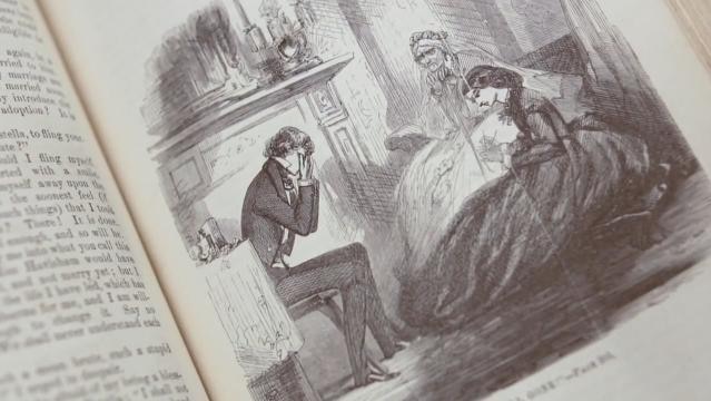 An drawing in an open old book of two women and a man
