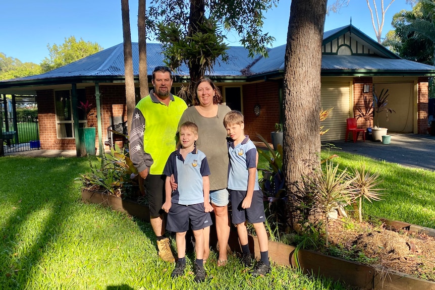 The Presley family, Steve and Rebecca with their sons Zac and Blake, stands outside their house.