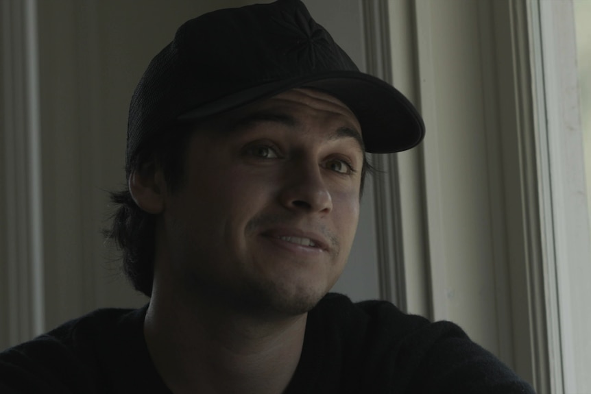 Brandon Thomas Lee con una gorra de béisbol y una camisa negra