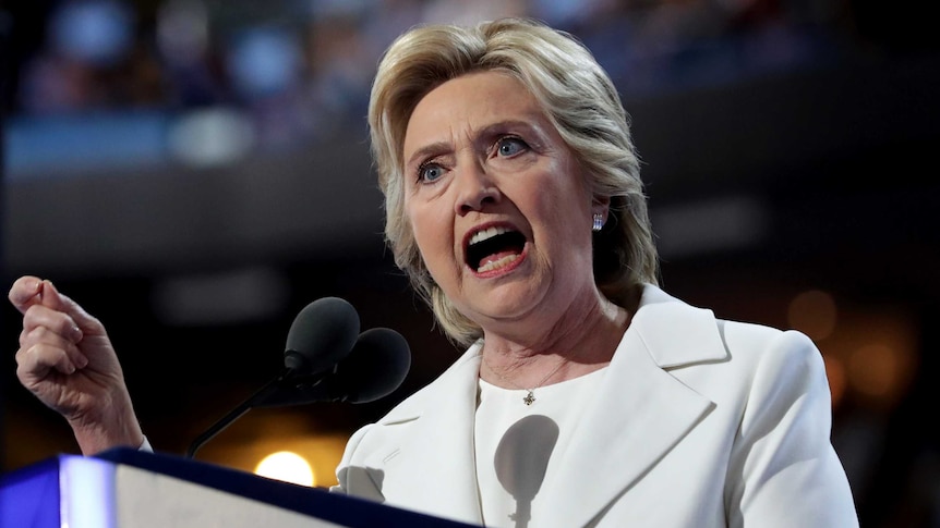 Hillary Clinton looks stern as she speaks at a lectern