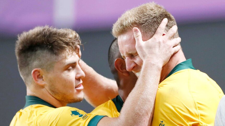 Two rugby union players embrace after a try at the Rugby World Cup.