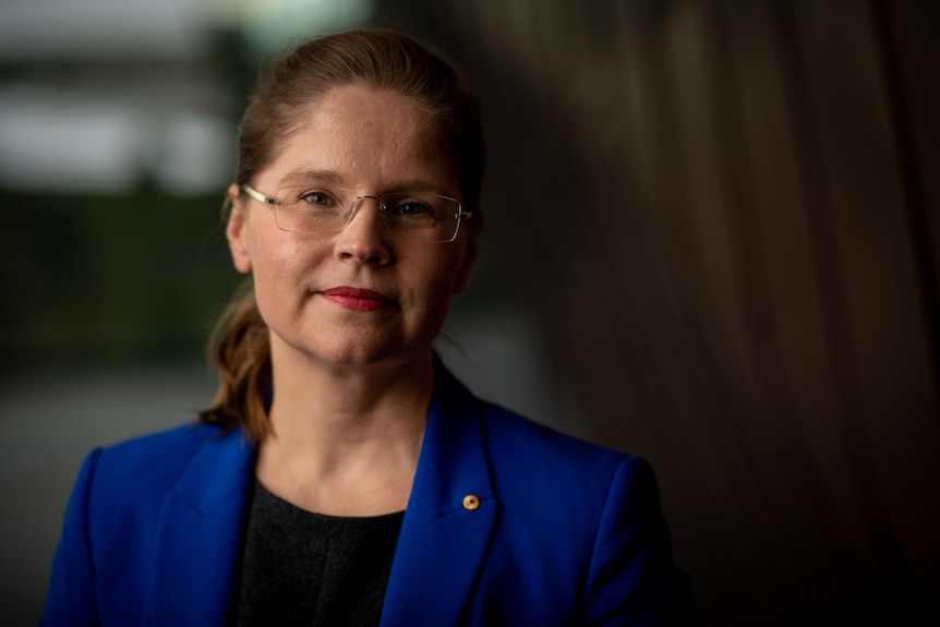 A woman wearing a blue blazer looking at the camera 