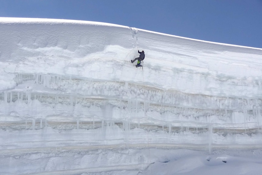 John All abseils down an icy ledge.