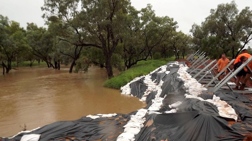 Workers in Charleville reinforce a flood barrier