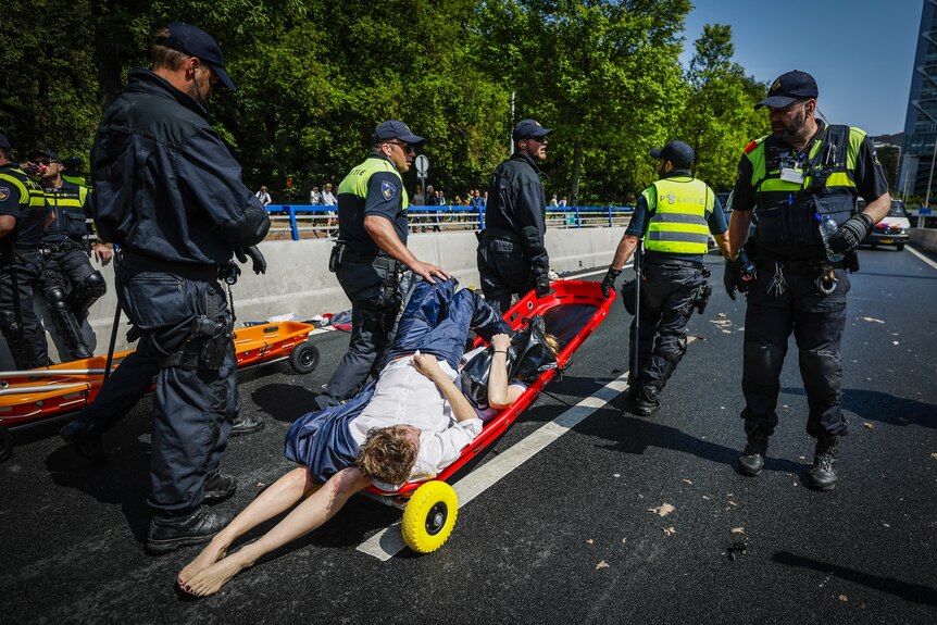 The police remove activists from Extinction Rebellion who are laying on a trolley.