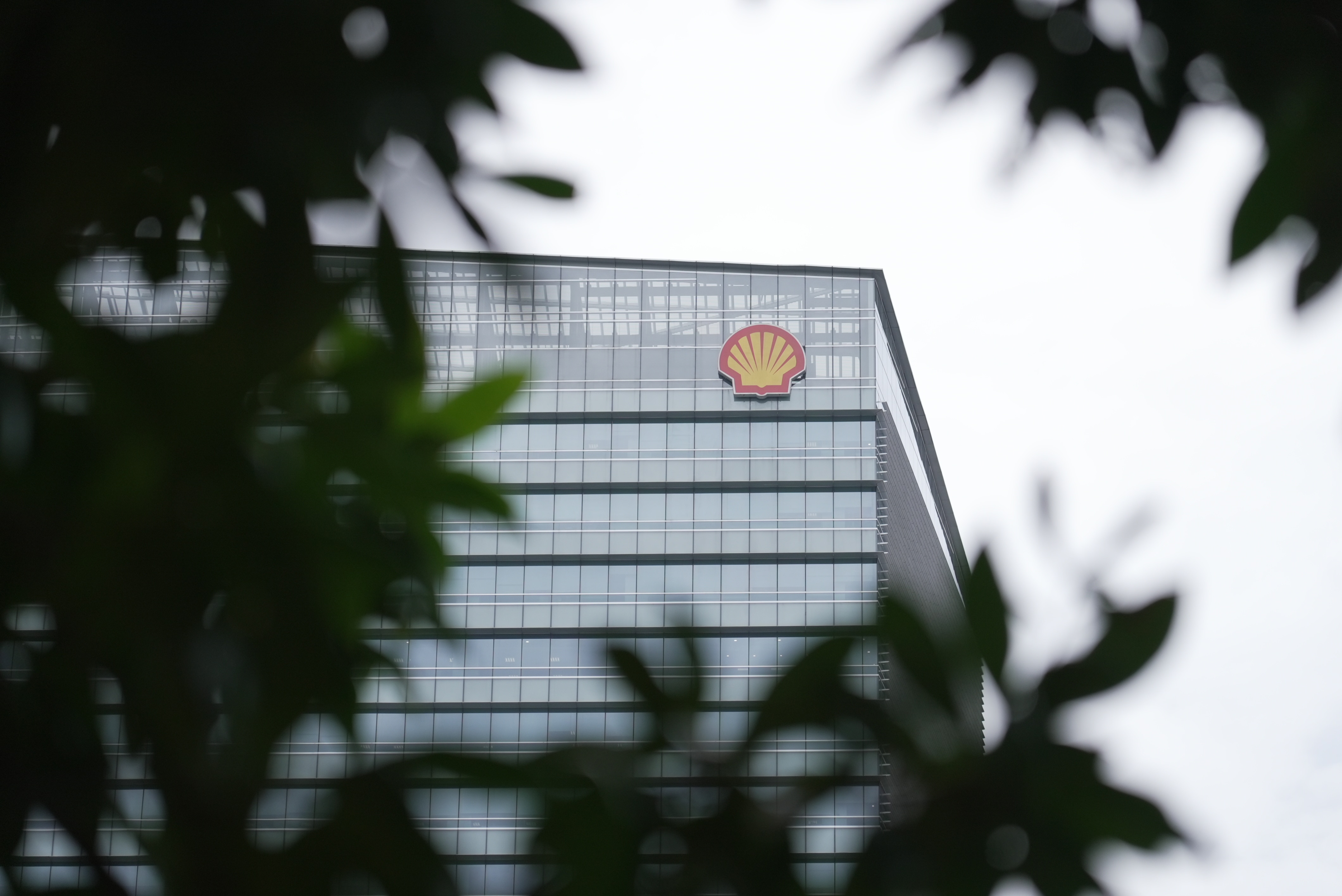 A tall building with the corporate logo of Shell on the exterior