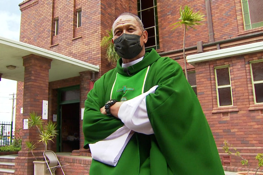 a priest outside a church wearing a mask