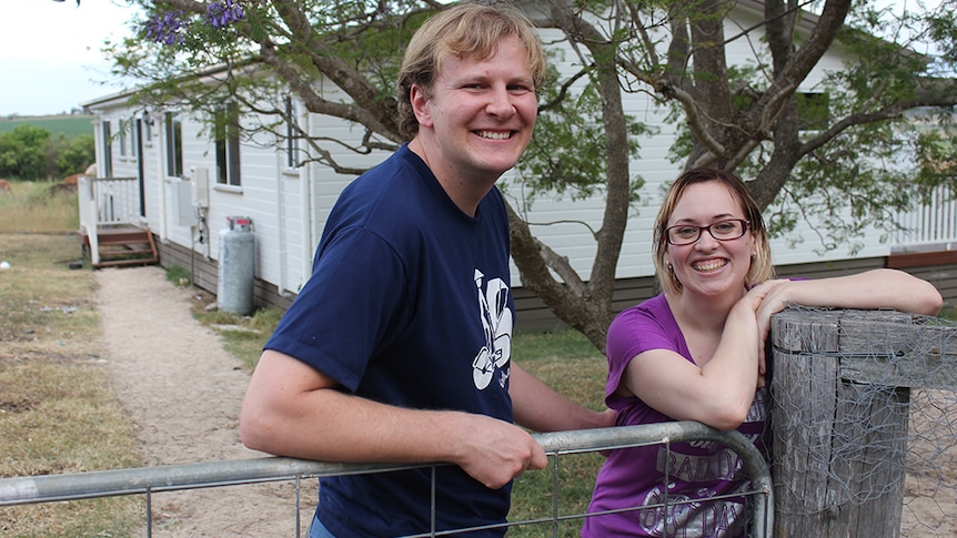 A couple stand in front of their transportable home