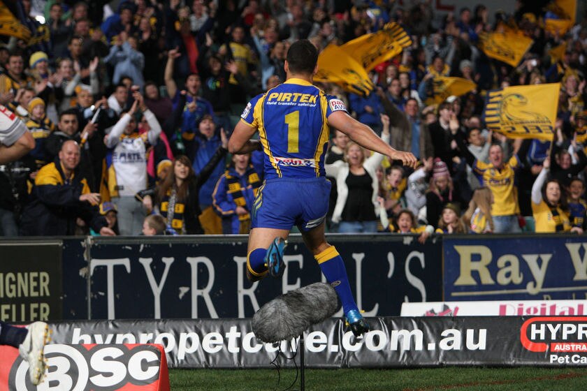 Jarryd Hayne hurdles a ground microphone after scoring a try for Parramatta against the Cowboys.