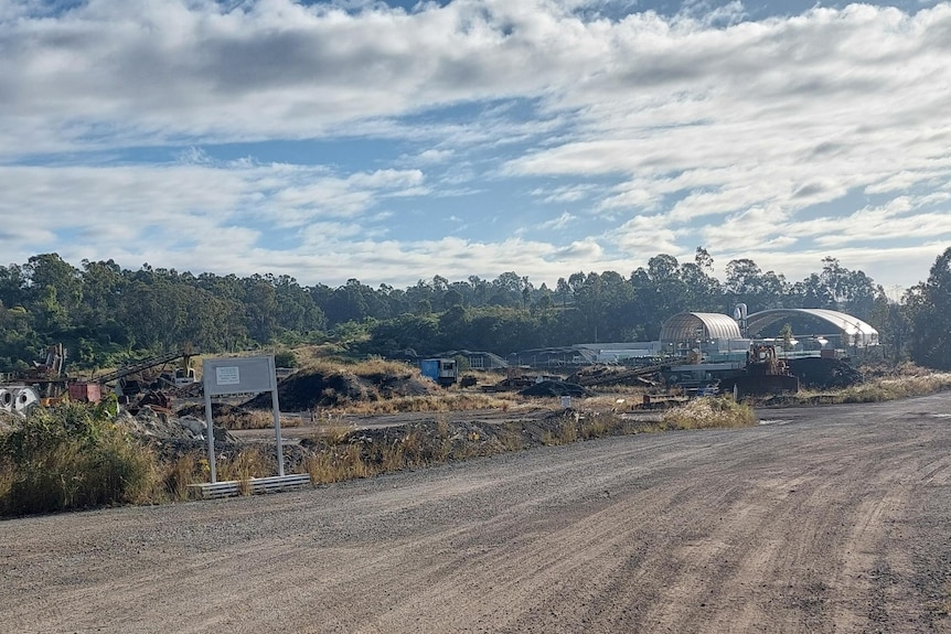 Outside the Chip Tyre site at New Chum, dusty road in the foreground with industrial business in the background