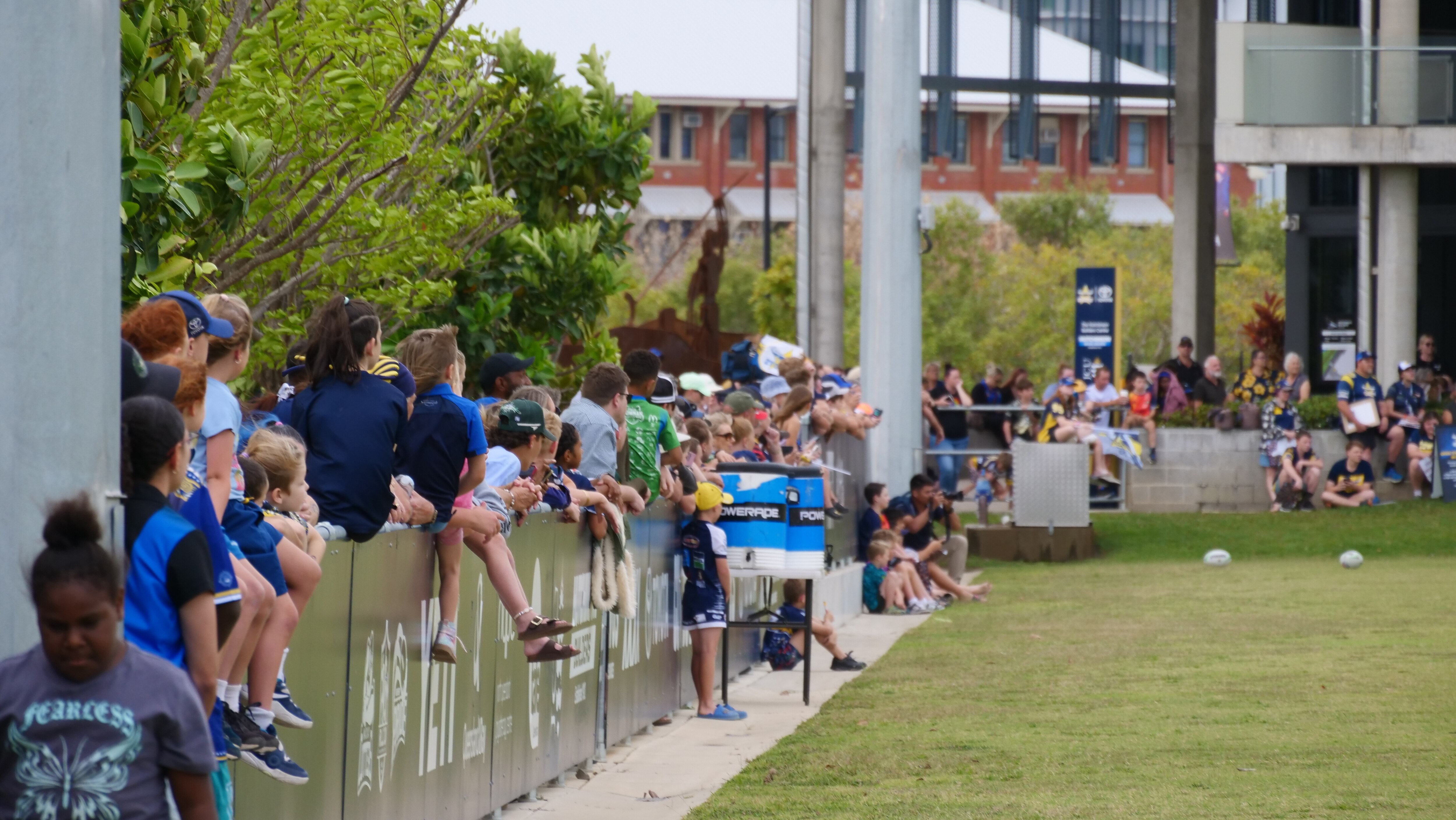 Crowd watches from sidelines of footy