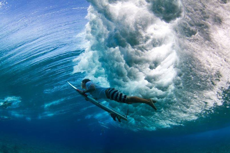 Australian-born pro surfer Jamie Mitchell under a breaking wave, location unknown.