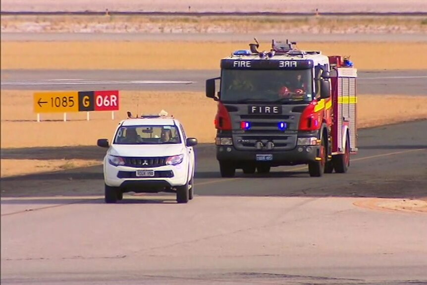 Fire trucks respond to an emergency on an airfield runway