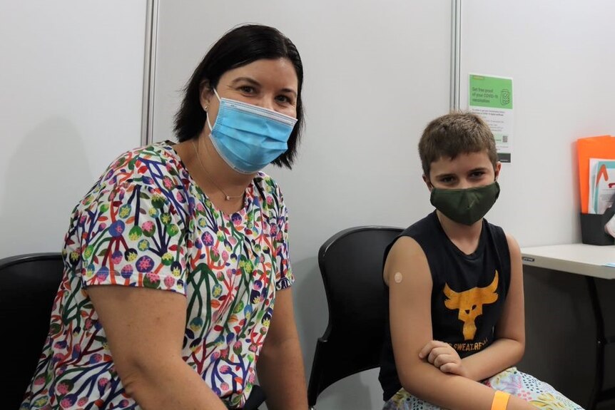 a woman wearing a colourful shirt and her son